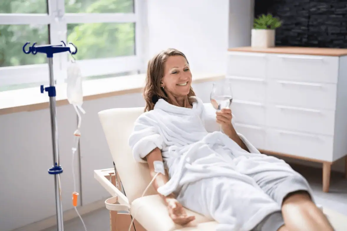Woman lounging in a robe, receiving IV hydration therapy at a wellness clinic in Provo, Utah